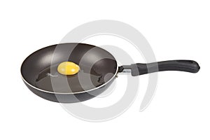 Raw egg in a frying pan isolated on white background