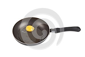 Raw egg in a frying pan isolated on white background