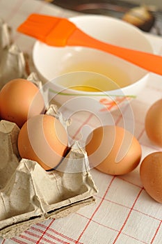 Raw eggs in box and egg yolk on plate with spices