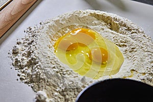 Raw Eggs in Flour for Pasta Prep on Countertop