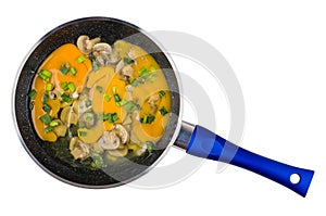 Raw eggs with fried mushrooms, chopped scallion in frying pan isolated on white. Top view