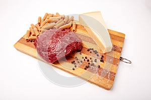 Raw Entrecote steak meat With Pepper and Salt pasta cheese On Wooden Board in a kitchen isolated on white