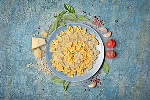Raw farfalle pasta with ingredients for pesto sauce