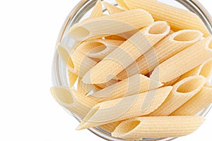 Raw feathers macaroni in bowl. Italian pasta close up, isolated on the white background