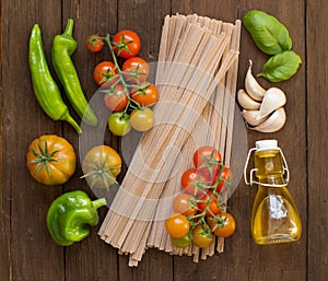 Raw fettucce pasta, vegetables and olive oil