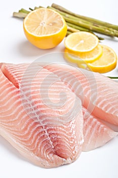 Raw filleted tilapia with asparagus photo