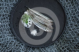 Raw fish European smelt uncooked on fishing net background