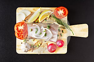 Raw fish meat, organic radish, lemon, onion and spice top view with closeup on cutting board. Fresh natural, organic, healthy and