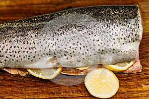 raw fish. raw fresh salmon, trout, on a table on a cutting board. with lemon ready for baking