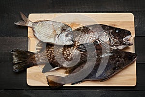 Raw fish on wooden cutting board