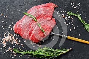 Raw Flat iron steak with rosemary and pink salt. Fresh Marble beef meat black Angus. Black background. Top view