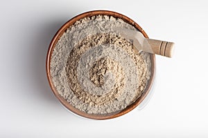 Raw flax seeds flour in a wooden bowl with on white background. Top view.