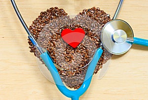 Raw flax seeds heart shaped and stethoscope