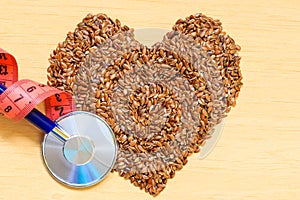 Raw flax seeds heart shaped and stethoscope