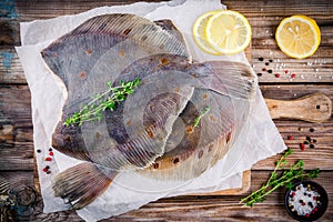 Raw flounder fish, flatfish on wooden table