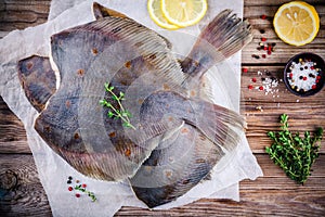 Raw flounder fish, flatfish on wooden table