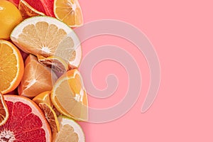 Raw food slicing and whole tropical citrus fruit on pink background.. Fresh citrus fruits background. Top view flat lay copy space