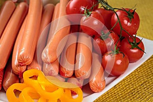 Raw frankfurter sausages on white plate