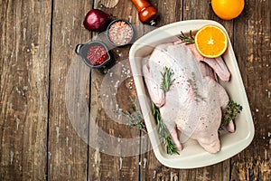 Raw free range duck with spices ready to cook on a wooden background, Culinary cooking. banner, menu, recipe place for text, top