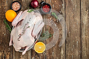 Raw free range duck with spices ready to cook on a wooden background, Culinary cooking. banner, menu, recipe place for text, top