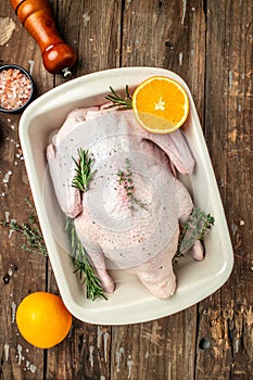 Raw free range duck with spices ready to cook on a wooden background, Culinary cooking. vertical image. top view. place for text