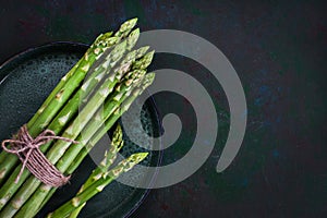 Raw fresh asparagus on rustic green background, top view