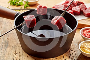 Raw fresh beef on fondue forks ready for dipping