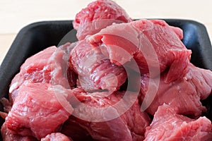 Raw fresh beef meat sliced â€‹â€‹in a black platter. Close up