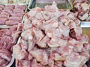 Raw fresh chicken meat of different cuts piled up on separate trays
