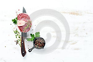 Raw fresh cross cut veal shank with spices and herbs on a white background. Cheese Bif steak Ossbo. Top view.