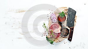 Raw fresh cross cut veal shank with spices and herbs on a white background. Cheese Bif steak Ossbo. Top view.