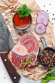 Raw fresh cross cut veal shank with spices and herbs on a white background. Cheese Bif steak Ossbo. Top view.