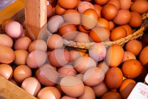 Raw fresh eggs in wicker basket at grocery store