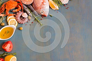 Raw fresh fish variety on blue wooden background with copy space.