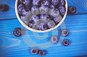 Raw fresh huckleberry in a bowl. Wooden background