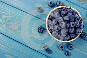 Raw fresh huckleberry in a bowl. Wooden background