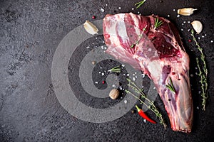 Raw fresh Lamb Meat shank and seasonings on black stone background