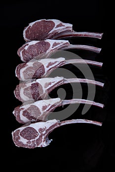 Raw fresh lamb ribs on dark background, close-up. Raw lamb chops. Rack of lamb on isolated background on black backdrop