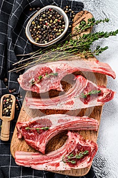 Raw fresh lamb ribs with pepper and thyme. Organic meat. White background. Top view