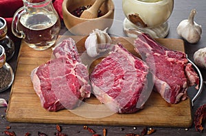 Raw fresh meat rib eye steak composition on wooden background