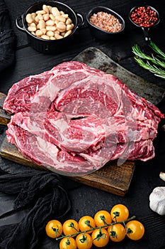 Raw fresh meat Ribeye steak entrecote of Black Angus Prime meat with ingredients, on black wooden table background