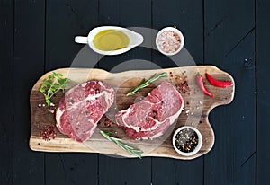 Raw fresh meat Ribeye steak entrecote and seasonings on cutting board