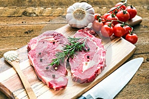 Raw fresh meat Ribeye steak entrecote with vegetables on wooden background