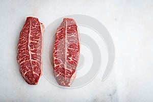 Raw fresh meat Top Blade steaks on light background. top view with copy space