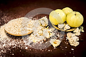 Raw fresh ripe Phyllanthus emblica,amla or Indian gooseberry with its powder on wooden surface.