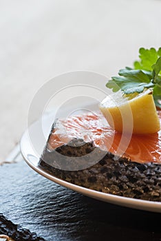 Raw fresh salmon cutlet steak with lemon and parsley garnish