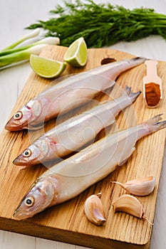 Raw fresh smelt fish on wooden board