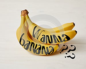 raw fresh yellow bananas on wooden background with Wanna banana? question
