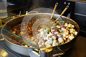 Raw and fried champignons in a frying pan