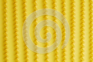 Raw fusilli lunghi pasta over yellow background